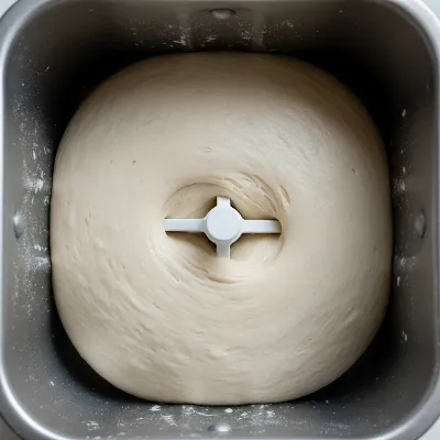 Bread dough in a bread maker forming a smooth, elastic ball during the kneading cycle, illustrating correct hydration