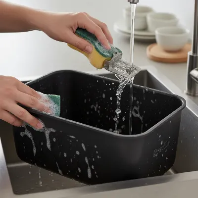 Close-up of a hand cleaning the Breville Custom Loaf's bread pan and collapsible paddle